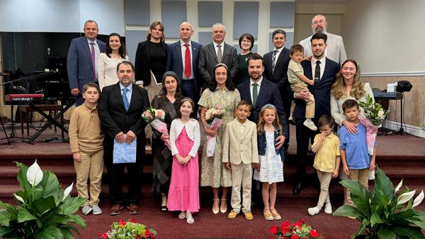 Pastors, ministers, and their families standing together on the church stage