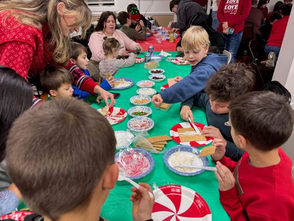 Kids at a table with peppermint plates and bowls of candy decorations